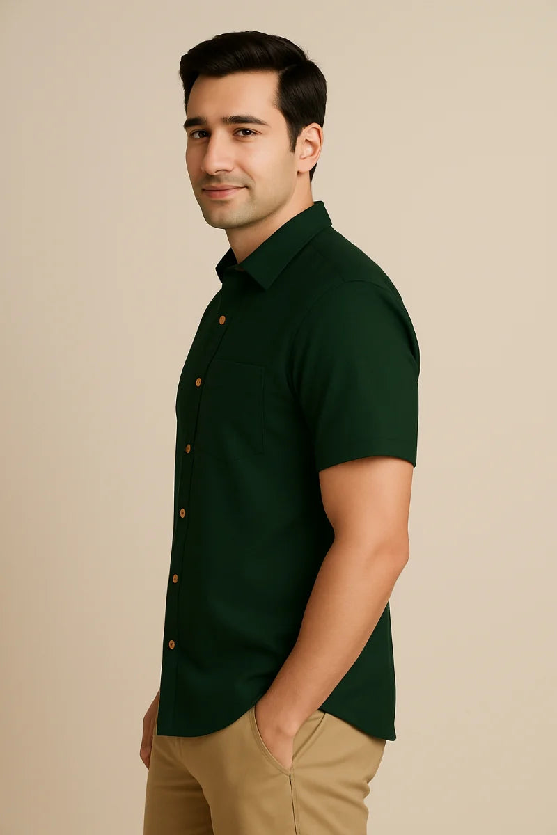 Man wearing a dark green shirt of crefa with buttons on a beige background